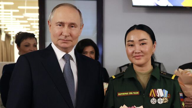 Президент РФ Владимир Путин и ветеран боевых действий Айдысмаа Монгуш во время встречи в Едином центре поддержки участников СВО